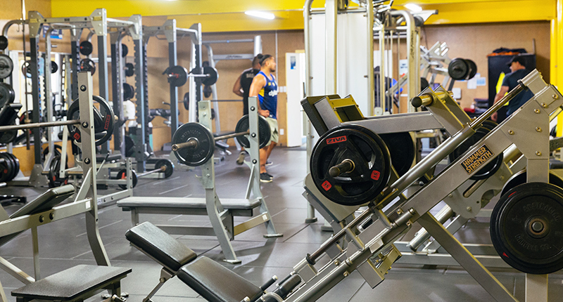 fitness centre with weight machines and guy standing in the background