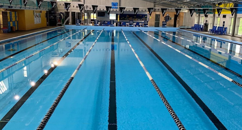 photo of pool with lane ropes and flags over the water